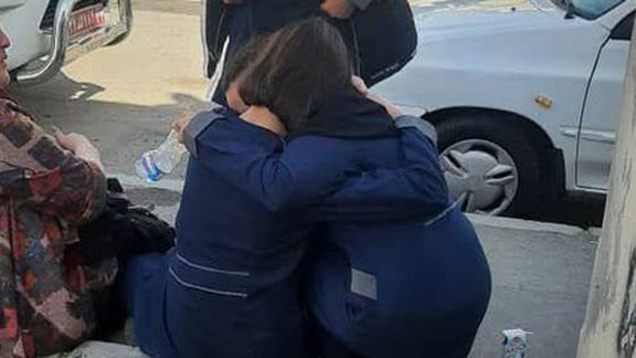 Two schoolgirls hugging each other after a poisonous gas attack at their school