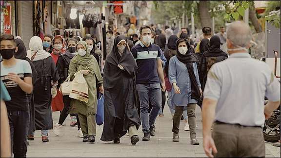 People walking in street in Tehran . Undated