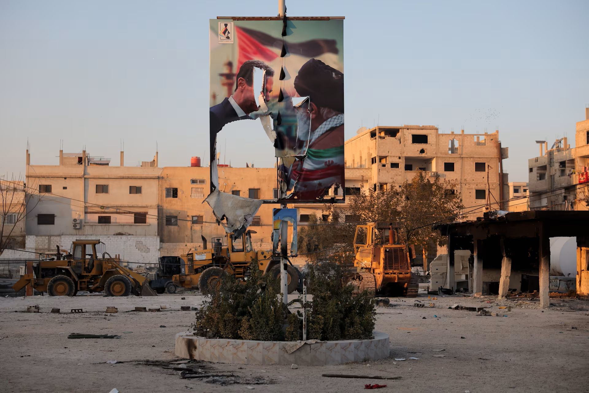 پوستر پاره‌شده‌ای از دیدار بشار اسد، رییس جمهور سابق سوریه، با علی خامنه‌ای در منطقه سیده زینب سوریه 