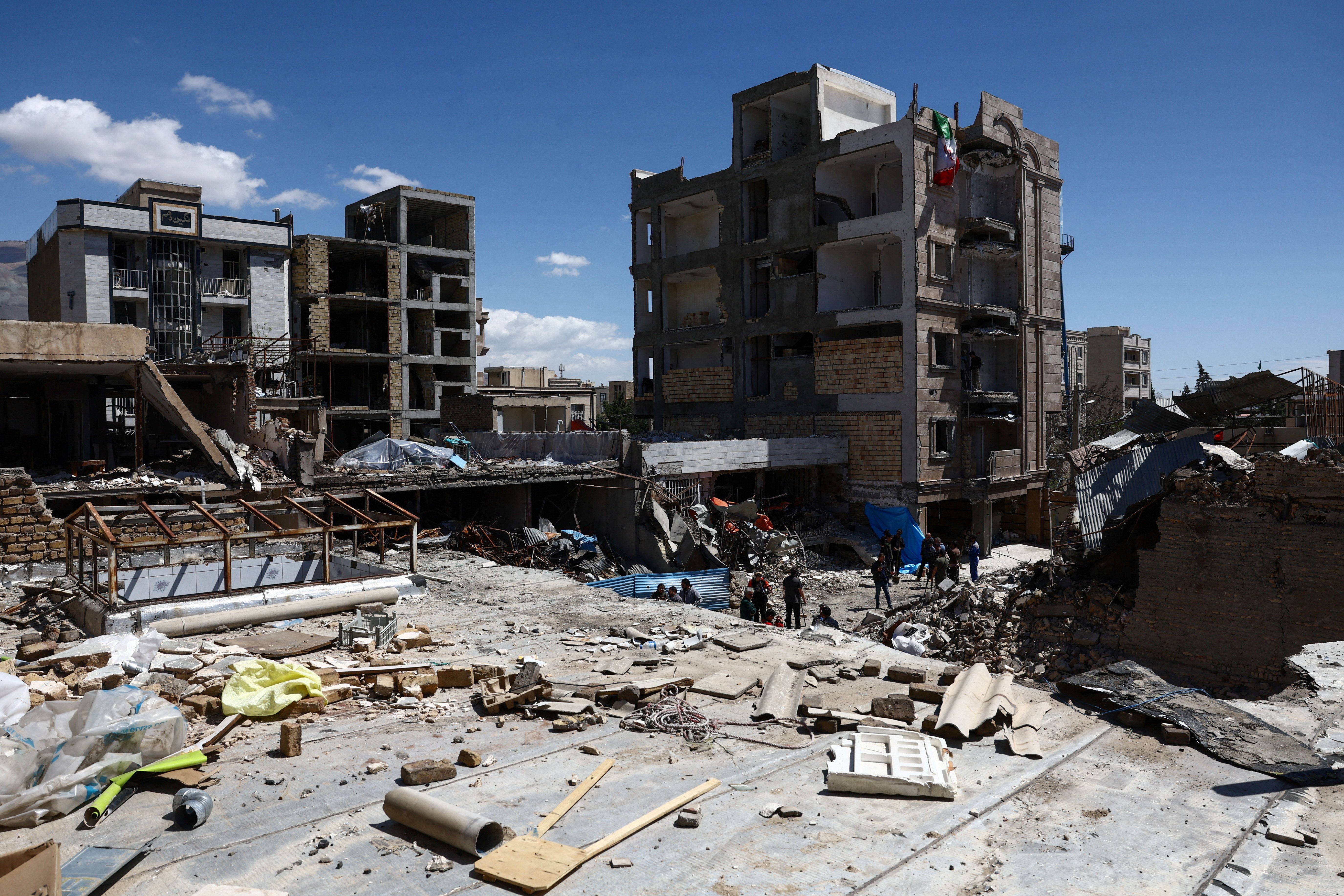People inspect the site of a residential building damaged by a strike, amid the US-Israeli conflict with Iran, in Karaj, Iran, April 3, 2026.
