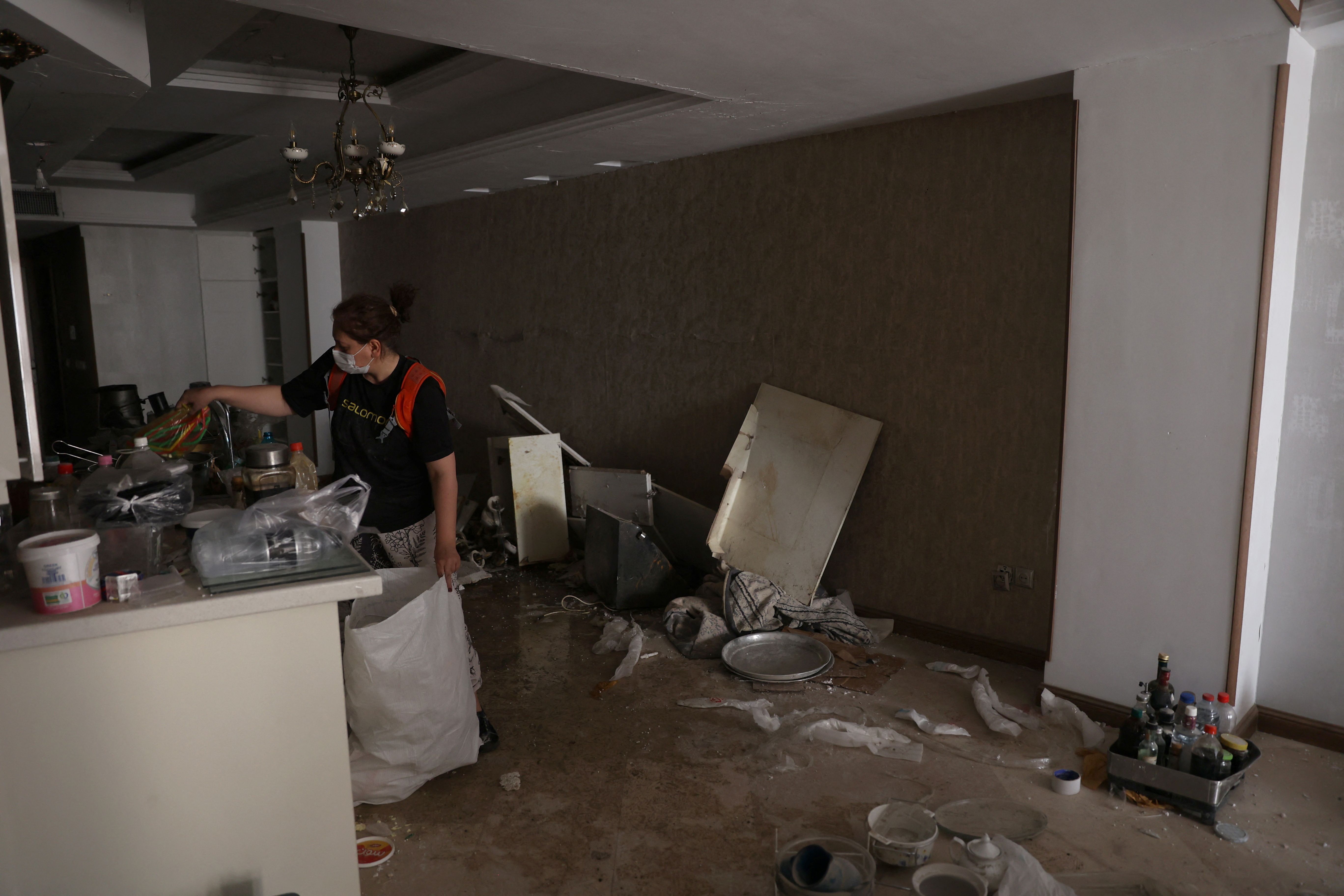 A woman works in her house after an Israeli strike on a building last week, after the ceasefire between Israel and Iran, in Tehran, Iran, June 25, 2025.