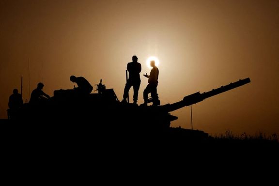 Israeli soldiers stand on a tank near Israel's border with Gaza in southern Israel, November 23, 2023.