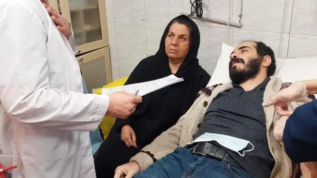 A photo of Hossein Ronaghi receiving medical care after release from prison
