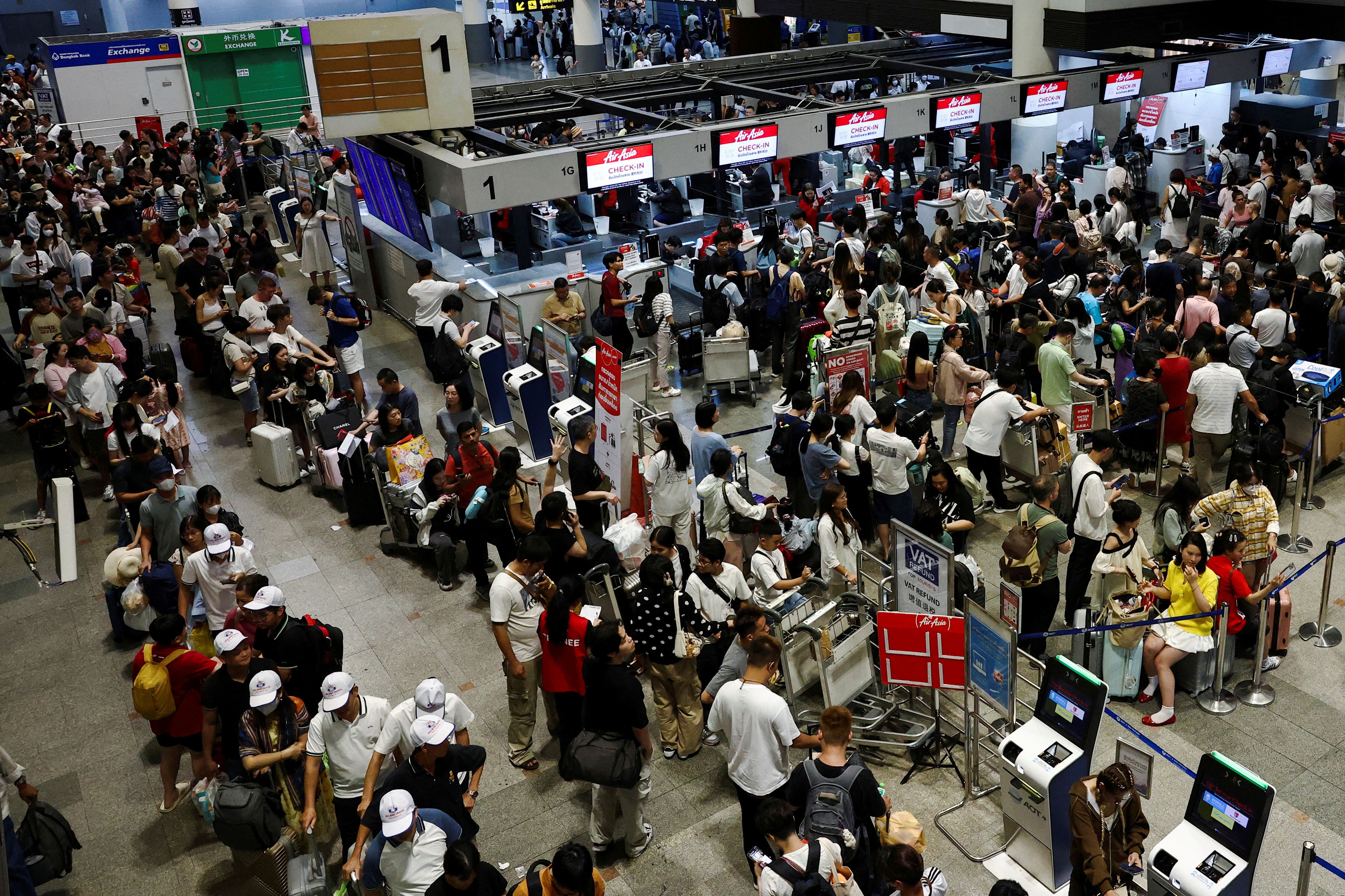 Air Asia passengers queue at counters inside Don Mueang International Airport Terminal 1 amid system outages disrupting the airline's operations, in Bangkok, Thailand, July 19, 2024. REUTERS