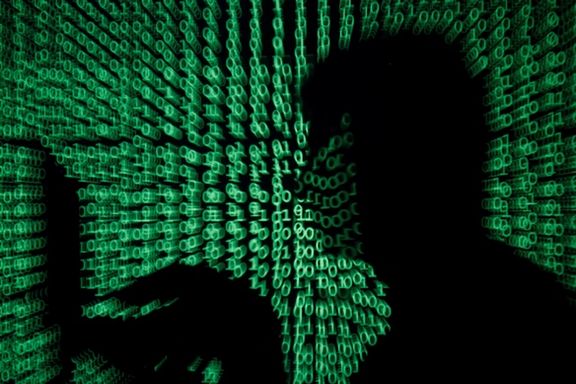 A man holds a laptop computer as cyber code is projected on him in this illustration picture taken on May 13, 2017.