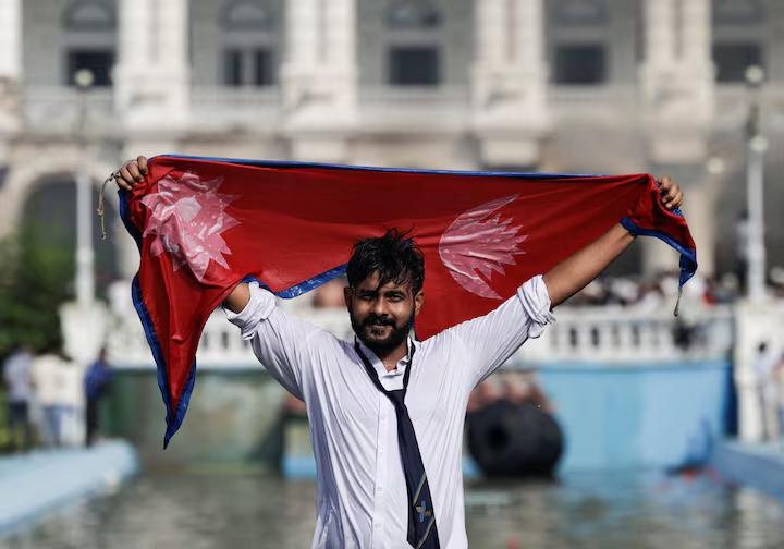 یک معترض با در دست داشتن پرچم نپال در محوطه سینگها دوربار، در جریان اعتراض‌ها به کشته شدن ۱۹ نفر پس از تجمعات ضدفساد، حضور دارد. کاتماندو، نپال؛ ۹ سپتامبر ۲۰۲۵.