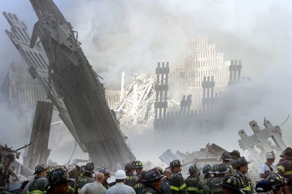 A group of firefighters stand on the street near the destroyed World Trade Centre in New York on September 11, 2001.