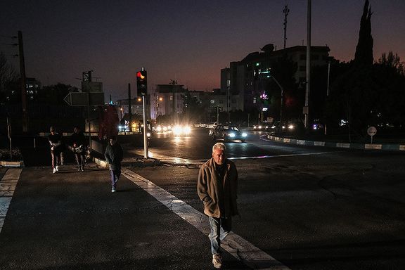 People cross a street during an evening blackout, Tehran, Iran (undated)