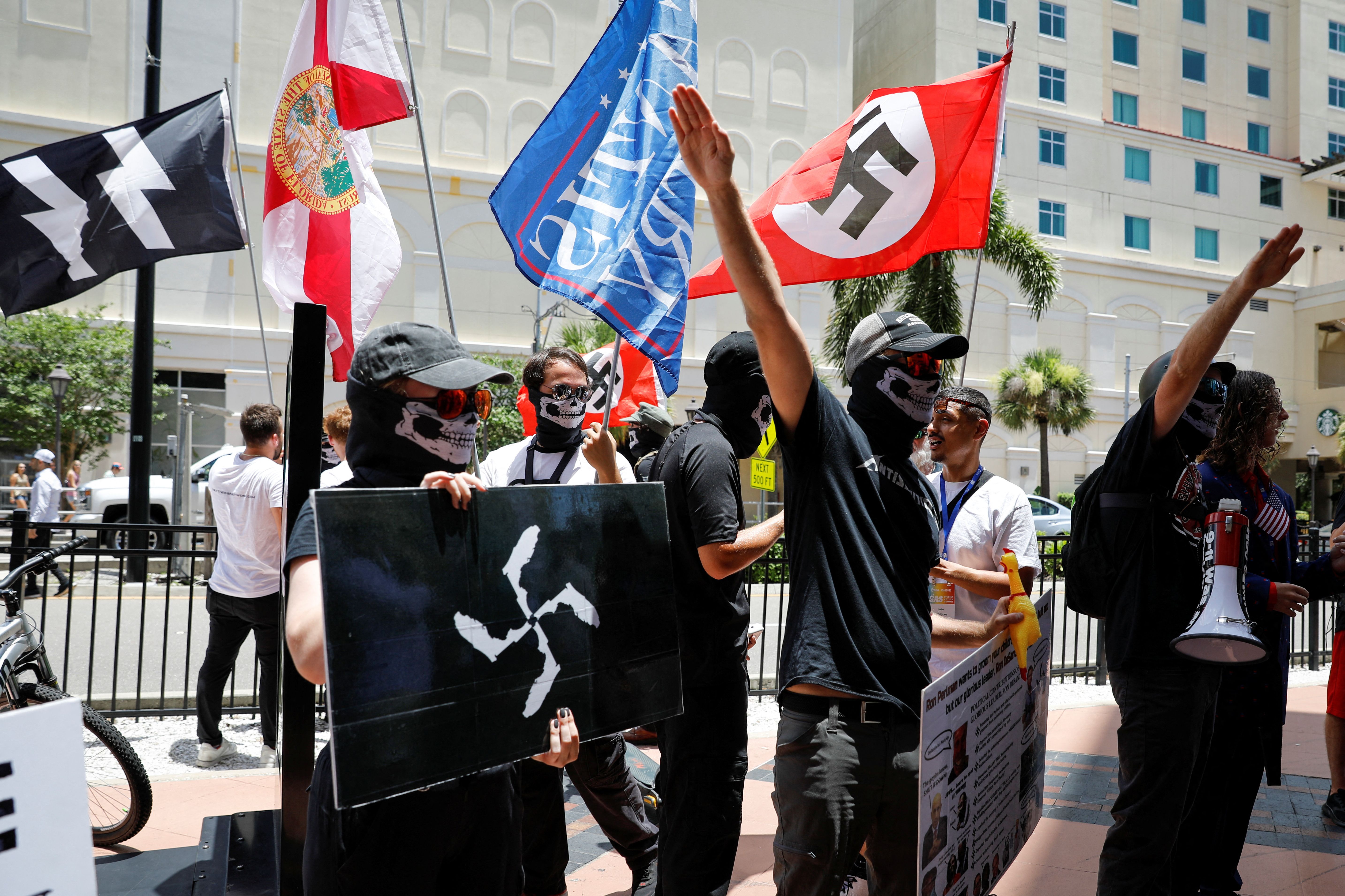 People wearing anti-semitic clothes wave Nazi flags, as they protest outside the Tampa Convention Center where Turning Point USA’s (TPUSA) Student Action Summit (SAS) is being held, in Tampa, Florida, U.S. July 23, 2022.