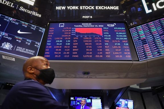 A trader stands beneath a screen on the trading floor displaying the Dow Jones Industrial Average at the New York Stock Exchange (NYSE) in Manhattan, New York City, September 13, 2022.