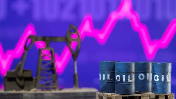 Models of oil barrels and a pump jack are displayed in front of a rising stock graph in this illustration taken February 24, 2022.