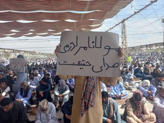An Iranian man holding a placard in support of the Sunni leader of Zahedan, Mowlavi Abdolhamid, during Friday prayers on March 10, 2023
