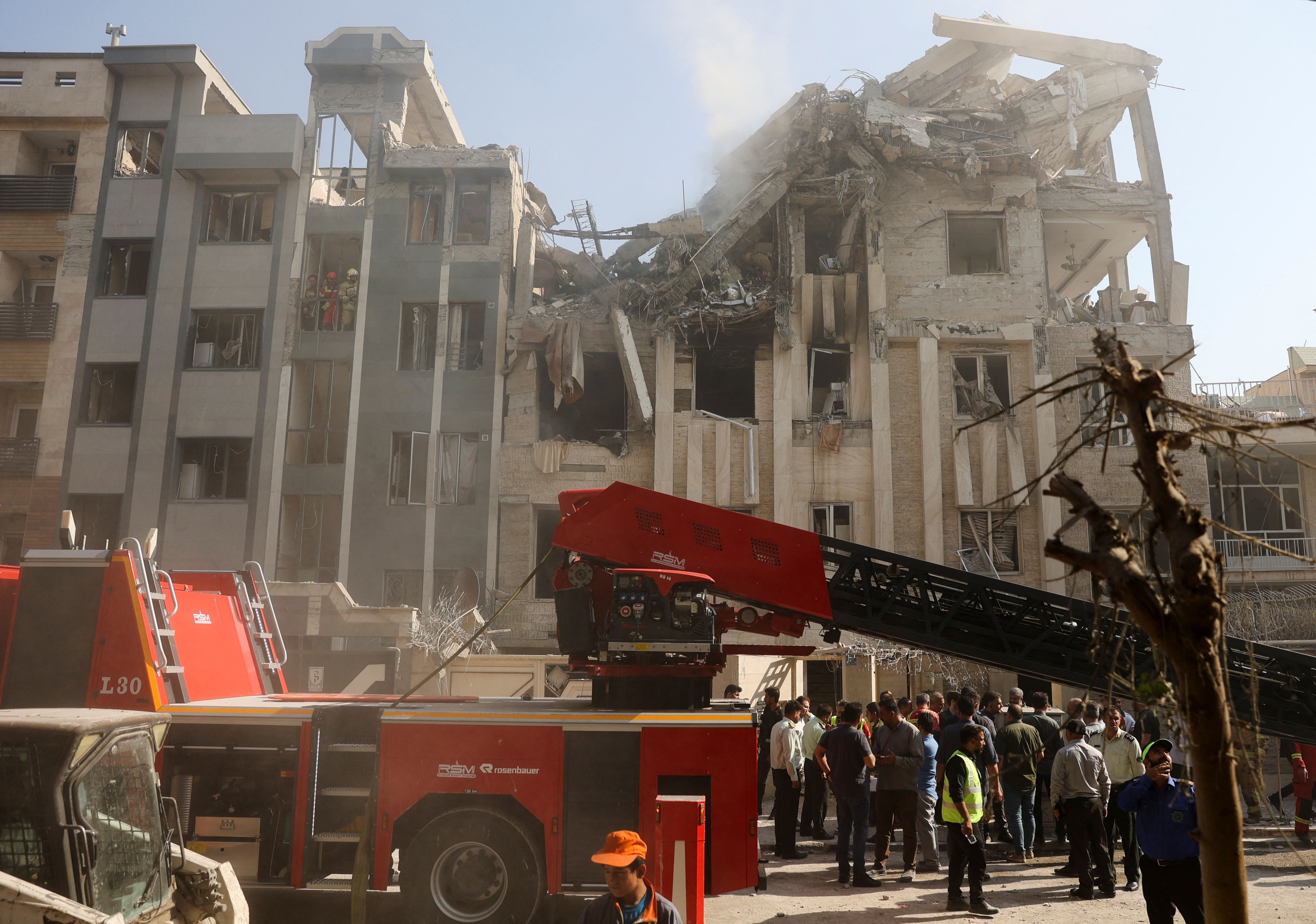 Rescuers work at the scene of a damaged building in the aftermath of Israeli strikes, in Tehran, Iran, June 13, 2025. 