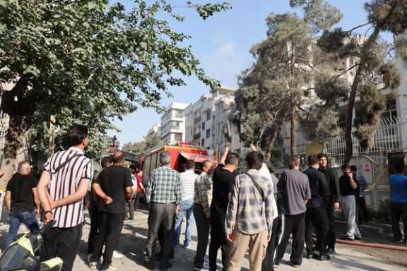 People gathered outside a building damaged by an Israeli strike in western Tehran on June 13, 2025.