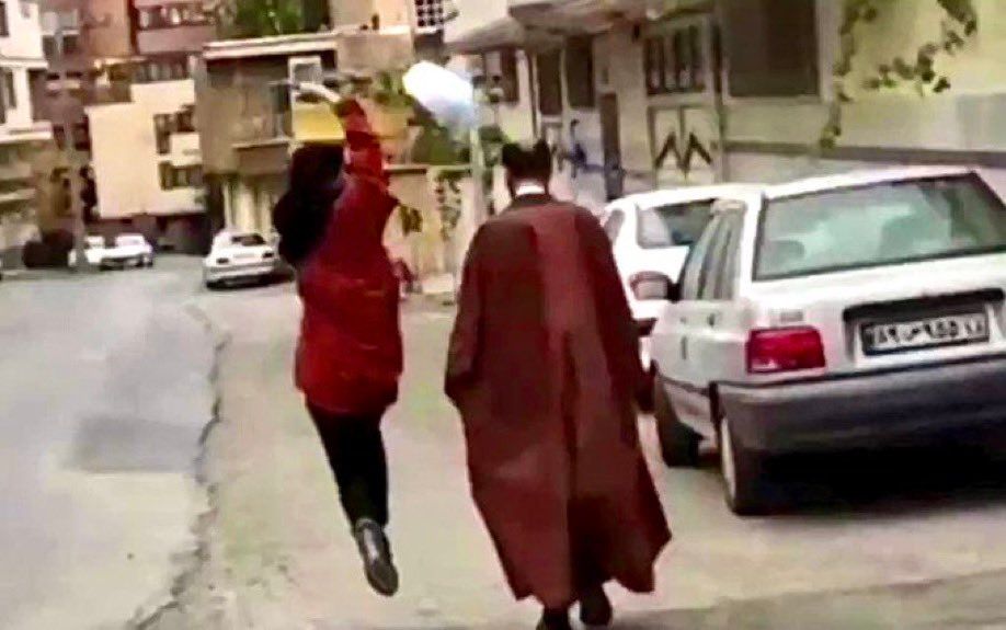 A girl flipping the turban of a cleric in Iran 