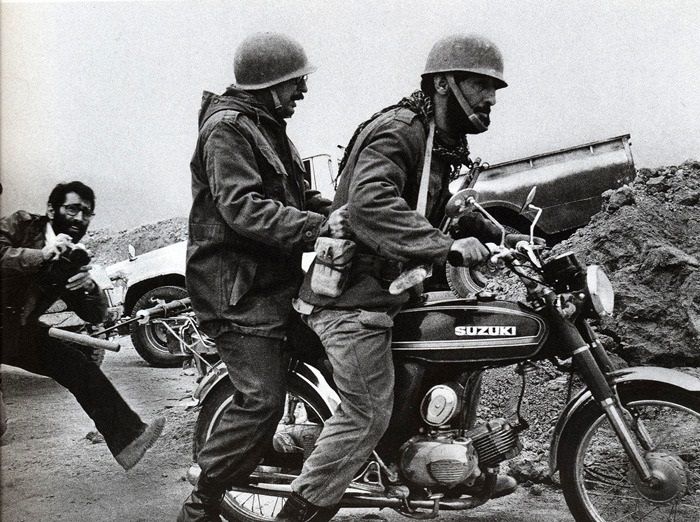 Banisadr at the back of a motorbike in the front during the Iran-Iraq war. Undated.