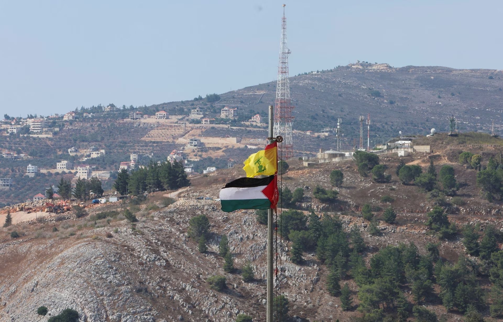 Palestinian and Hezbollah flags flutter in Khiam, near the border with Israel, in southern Lebanon October 9, 2023. 