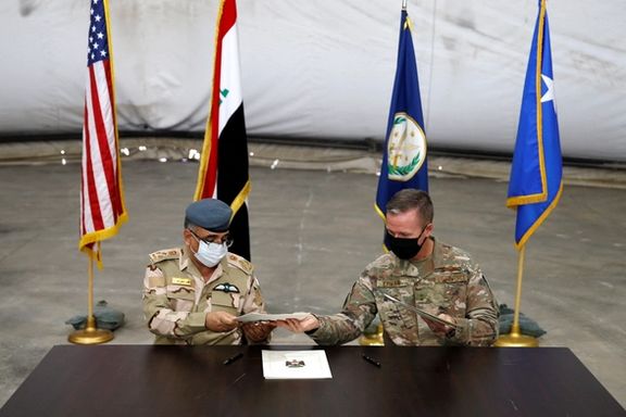 Maj. Gen. Kenneth P. Ekman, Deputy Commander of Combined Joint Task Force-Operation Inherent Resolve, signs documents with Brigadier General Salah Abdullah during a handover ceremony of Taji military base from US-led coalition troops to Iraqi security forces, in the base north of Baghdad, Iraq August 23, 2020.