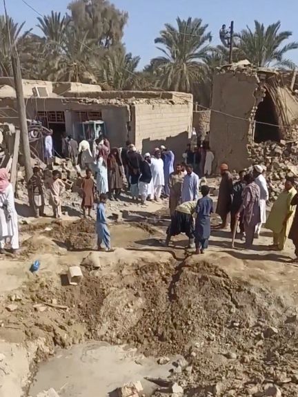 People gather near rubble in the aftermath of Pakistan's military strike on an Iranian village near Saravan, Sistan and Baluchestan Province, Iran, January 18, 2024.