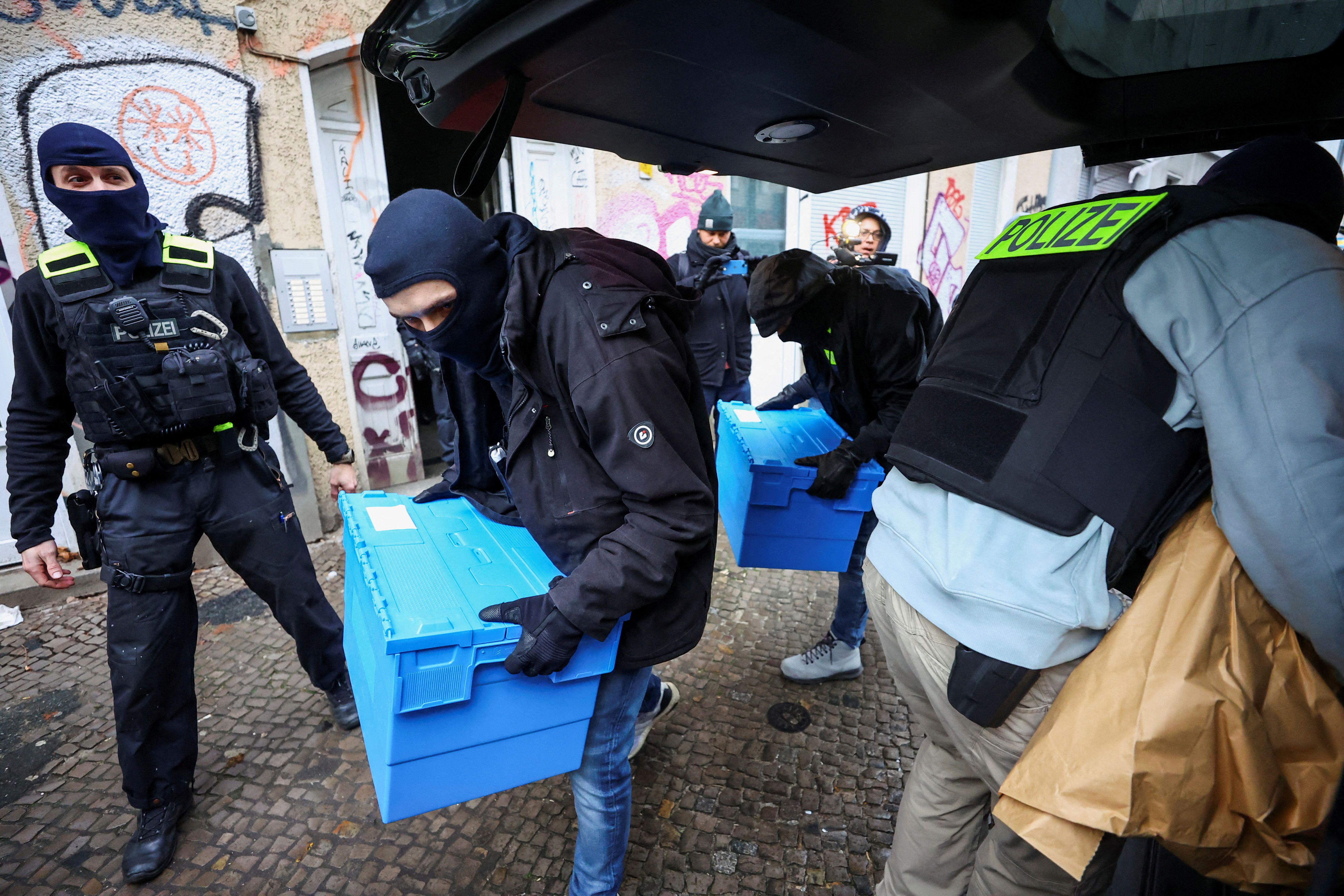 German police officers carry evidence collected at an apartment building during a raid against people supporting the Palestinian Islamist group Hamas, in Berlin, Germany, November 23, 2023. 