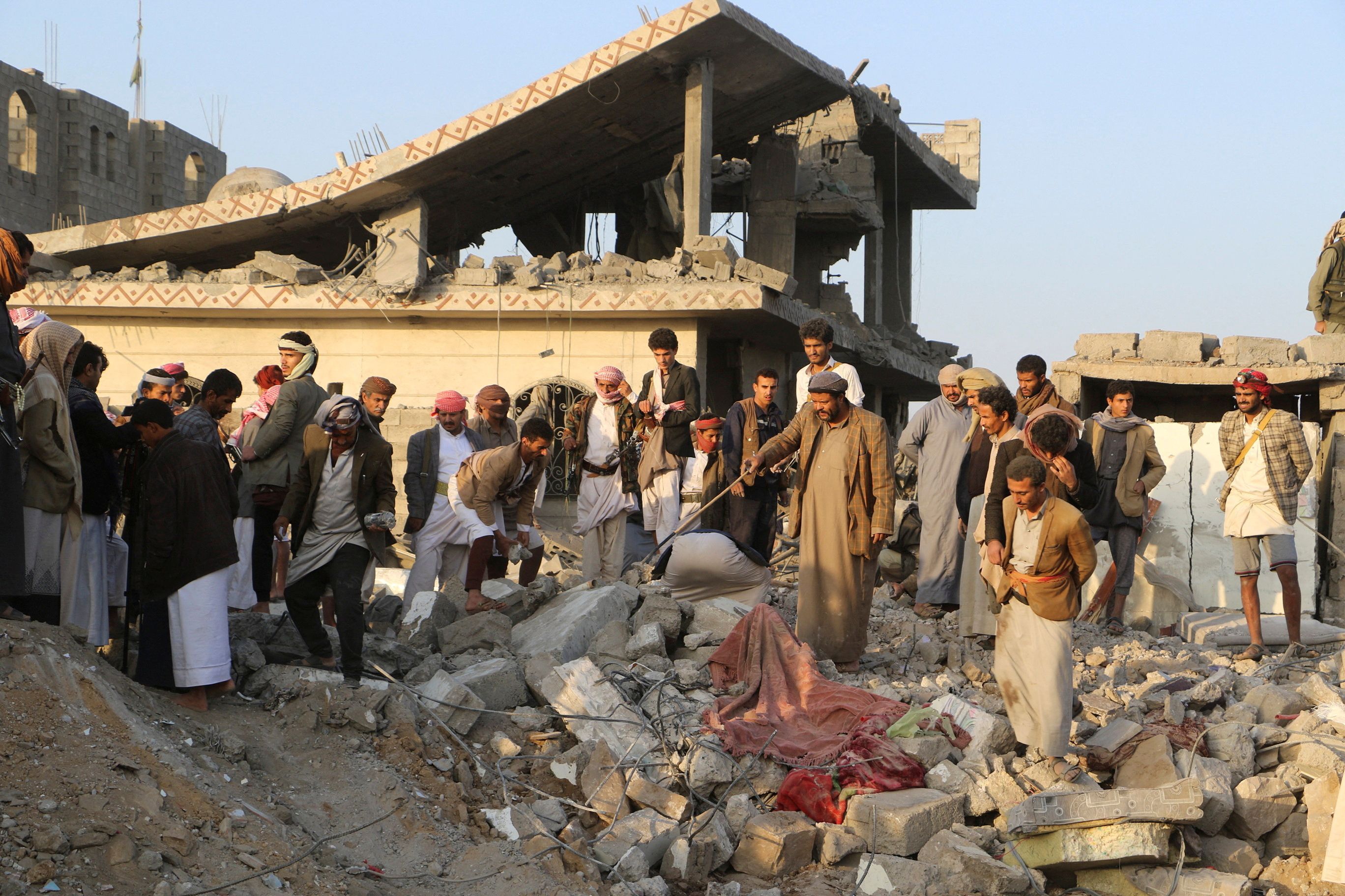 People gather on the rubble of a house hit by a US strike in Saada, Yemen March 16, 2025. 