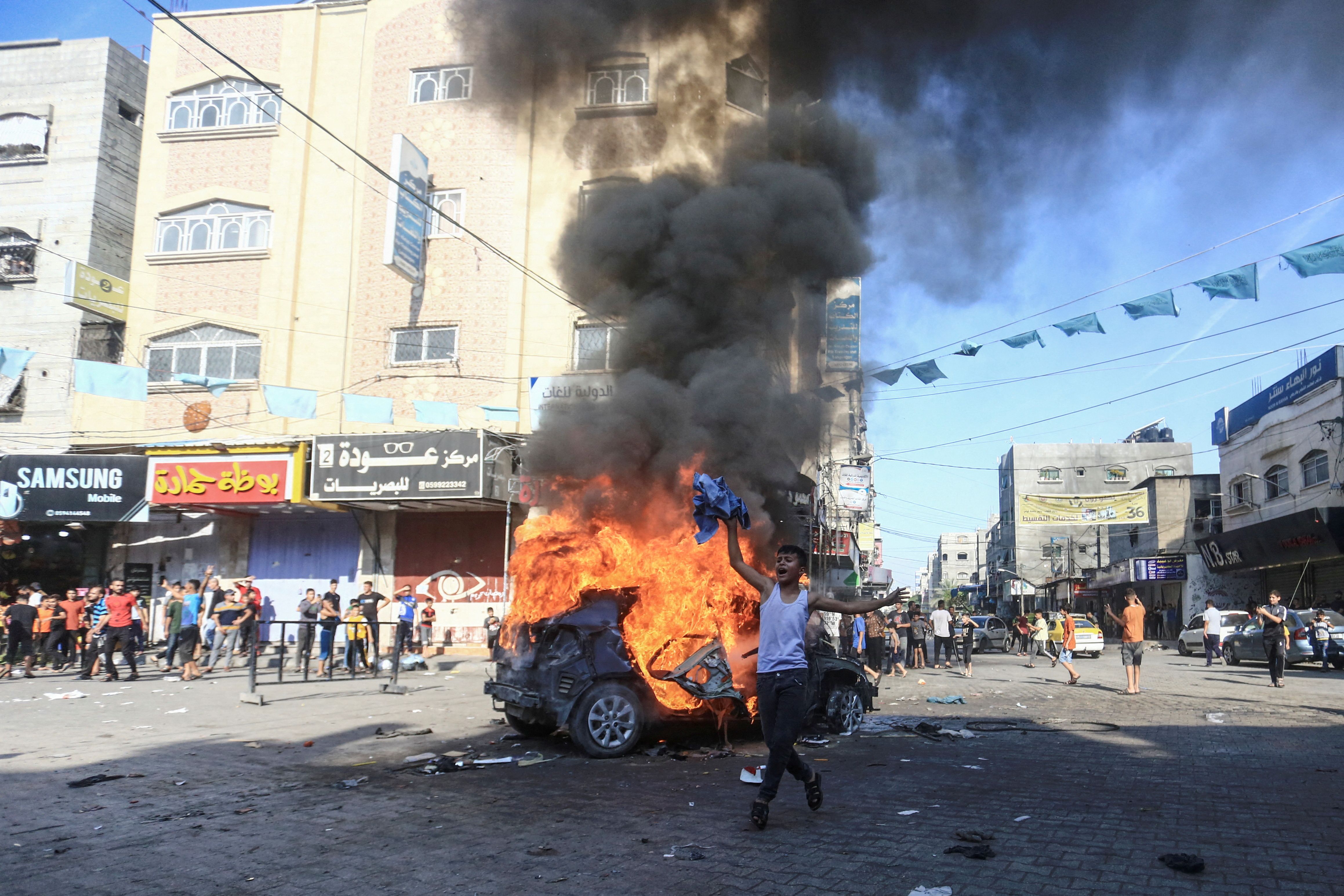 A Palestinian boy reacts next to a burning Israeli vehicle that Palestinian gunmen brought to Gaza after they infiltrated areas of southern Israel, in the northern Gaza Strip October 7, 2023.