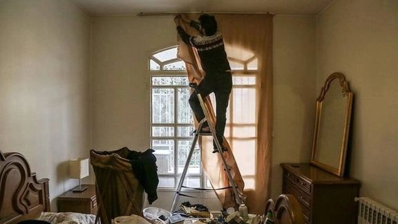 An Iranian man installs curtains at home as part of preparations ahead of the Nowruz new year celebrations.