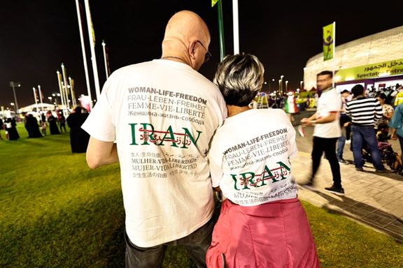 زن و مرد هوادار فوتبال با تیشرت منقش به «زن زندگی آزادی» در قطر