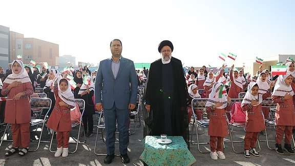 Iran’s Education Minister Reza Morad Sahraei (left) and President Ebrahim Raisi among schoolgirls during a ceremony in Tehran