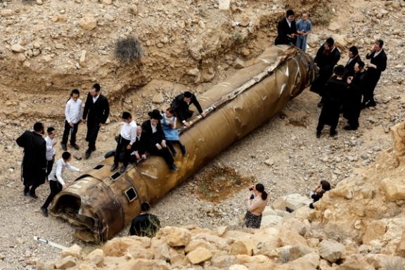 Ultra Orthodox Jews hang around apparent remains of a ballistic missile before it has been evacuated from the location it was found lying in the desert, following a massive missile and drone attack by Iran on Israel, near the southern city of Arad, Israel April 26, 2024.