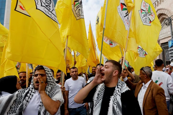 People hold Fatah flags during a protest in support of the people of Gaza, as the conflict between Israel and Palestinian Islamist group Hamas continues, in Hebron, in the Israeli-occupied West Bank, October 27, 2023.