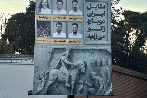 لافتة أمام السفارة البريطانية وشعارها "ستركعون مجدداً أمام إيران"