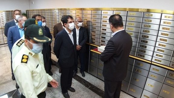 Officials and police inspect a section of safety deposit boxes at Bank Melli.