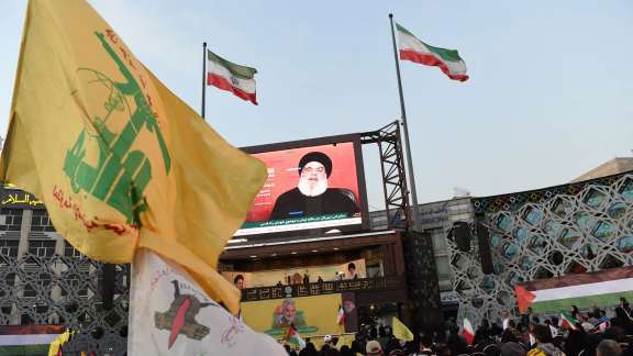 People listen to Hezbollah leader Hassan Nasrallah's speech through a screen during a gathering in Tehran, Iran, November 3, 2023.