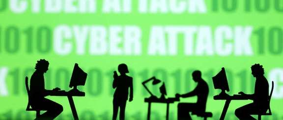 Miniatures of people with computers are seen in front of binary codes and words 'Cyber attack' in this illustration taken July 19, 2023.