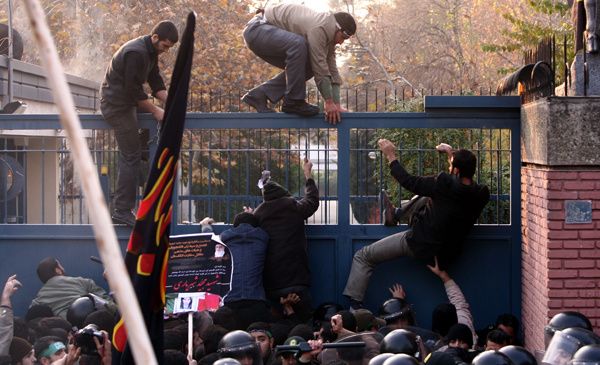 Ultra-hardliner protesters climbing over the gate of the UK Embassy in Tehran in November 2011