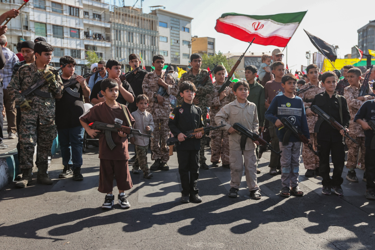 Children hold rifles during the state-organized Janfadayan-e Iran parade in Tehran on September 18, 2026.