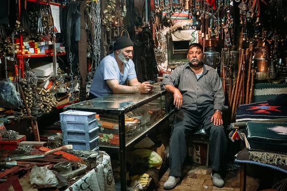 Traders sit idly in a shop selling religious accessories in holy city of Qom, Iran, October 21, 2025