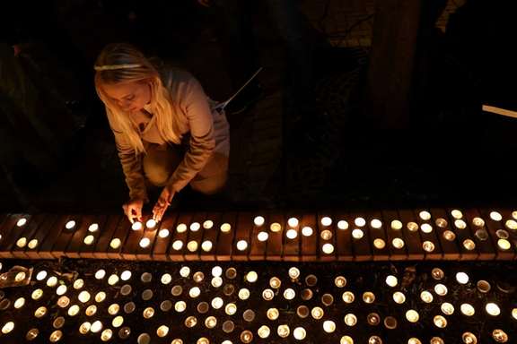 A woman lights a candle during a commemoration of the first anniversary of the October 7 Hamas attacks on Israel at the the Dohany Street Synagogue in Budapest, Hungary.
