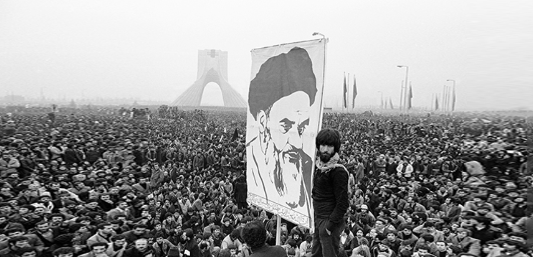 Iranian demonstrator holds poster of Khomeini as uprisings swept Iran in 1978. 