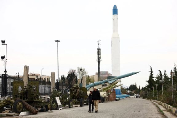 An Iranian couple walks near Iranian missiles in a park in Tehran, March 26, 2026.