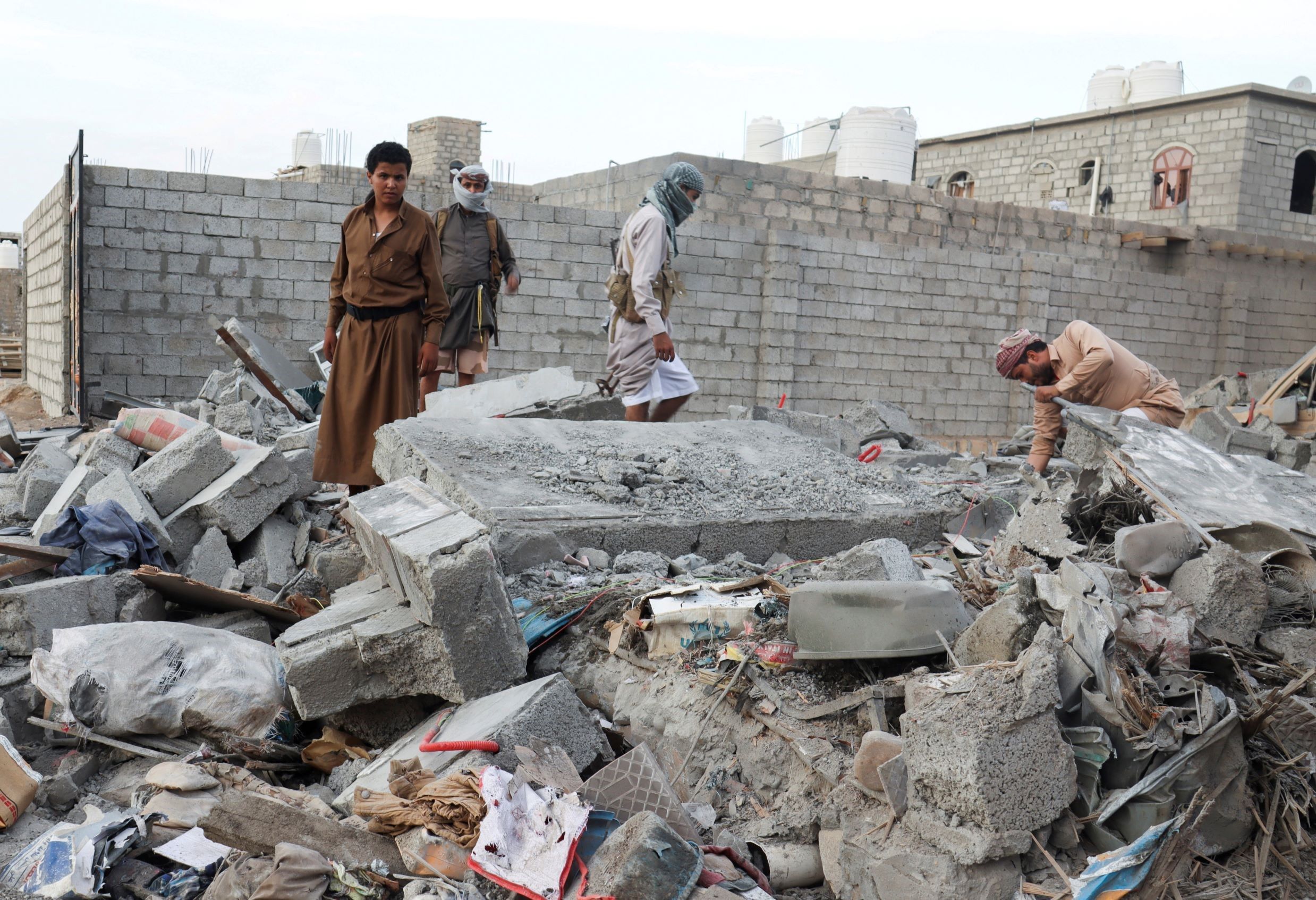 People browse through the rubble of a house destroyed by Houthi missile attack in Marib, Yemen, October 3, 2021 