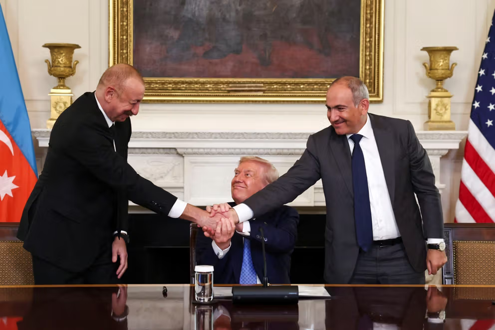 US President Donald Trump holds the hands of Azerbaijan's President Ilham Aliyev and Armenia's Prime Minister Nikol Pashinyan as they shake hands between each other during a trilateral signing event, at the White House, in Washington, DC, August 8, 2025.