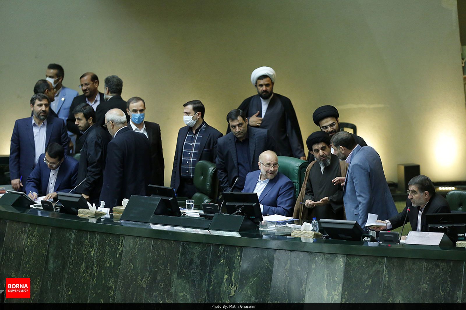 Iranian lawmakers mingle at the presidium stage of parliament.
