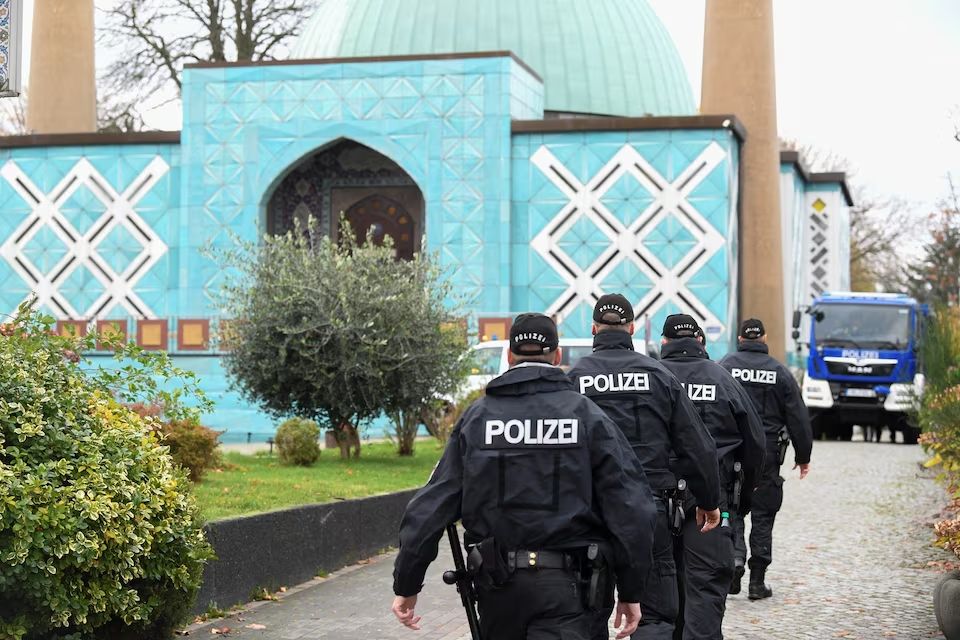 German police officers walk towards the Islamic Center Hamburg, during a raid, due to suspicion of members acting against a constitutional order and supporting the militant group Hezbollah in Hamburg, Germany. 