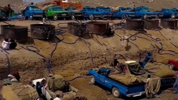 Nissan pickup trucks in Iran being loaded with gasoline for smuggling