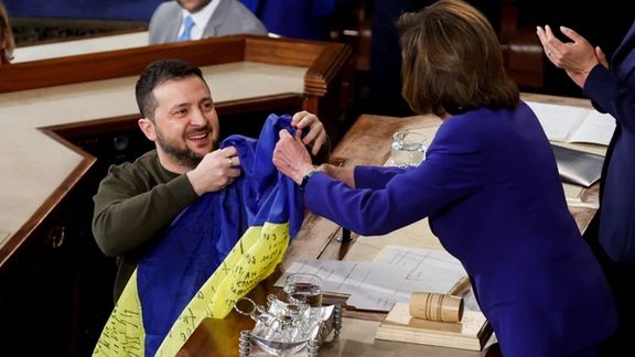 President Volodymyr Zelenskiy presents a Ukrainian flag given to him by defenders of Bakhmut to US House Speaker Nancy Pelosi during a joint meeting of US Congress, December 21, 2022