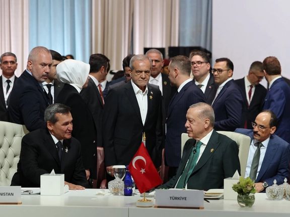 Iranian President Masoud Pezeshkian (center) stands next to Turkish President Recep Tayyip Erdoğan (seated on the right) during the OIC–Arab League Extraordinary Summit in Doha on September 15, 2025 / Photo by Turkish Presidency