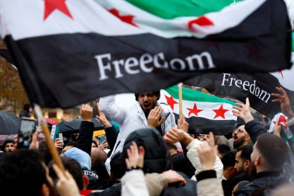 People hold Syrian opposition flags as they celebrate at the Place de la Republique, after Syrian rebels announced that they have ousted President Bashar al-Assad, in Paris, France, December 8, 2024.