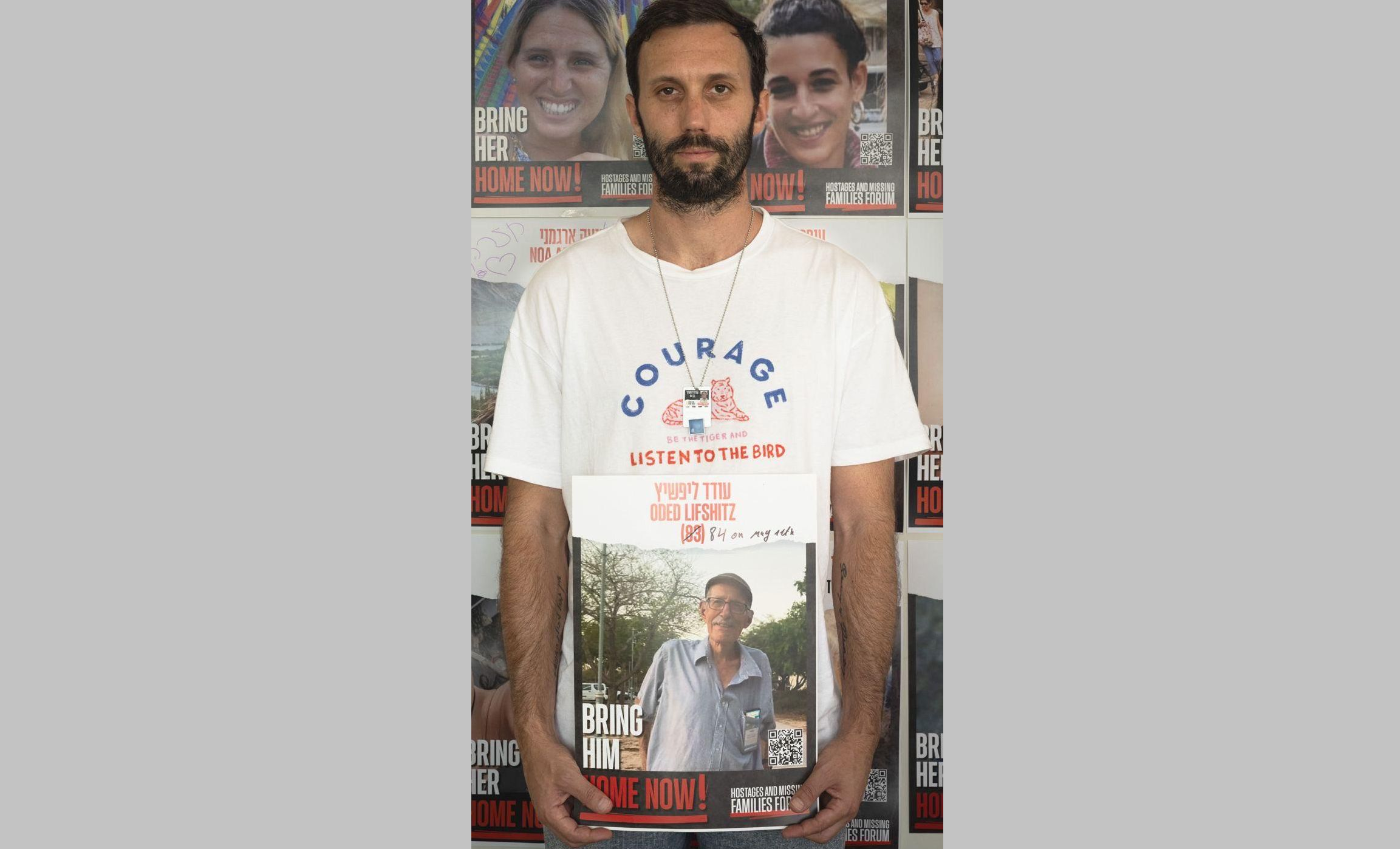 Daniel Lifshitz holding a photo of his grandfather Oded Lifshitz, still a hostage in Gaza.